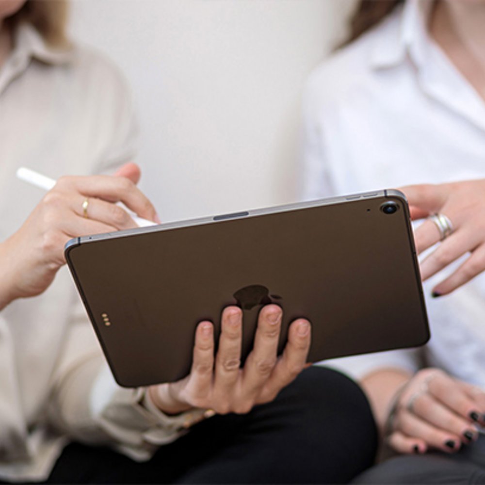 Zwei Mitarbeiterinnen von edoc schauen auf ein Ipad