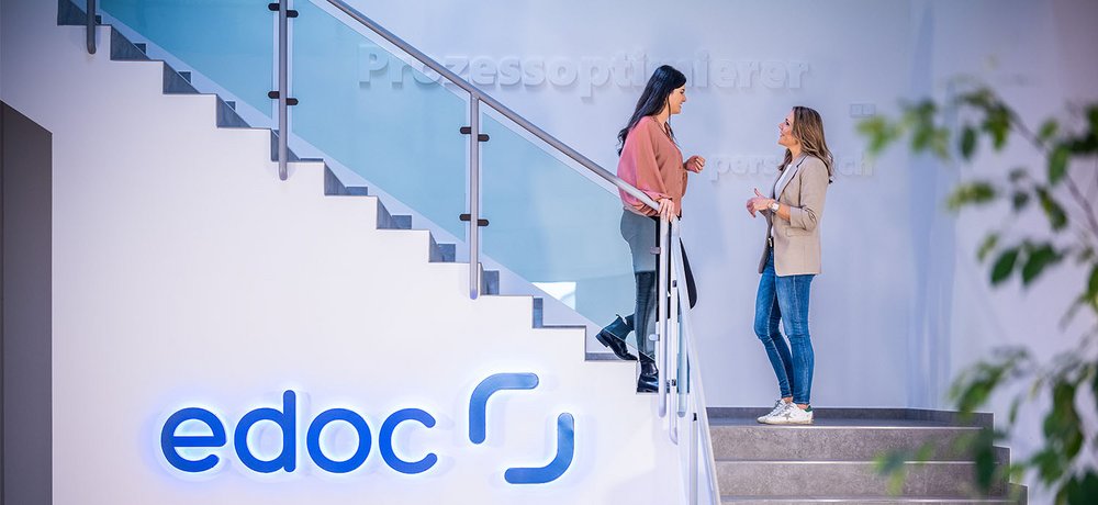Zwei ECM-Spezialistinnen von edoc unterhalten sich auf einer Treppe